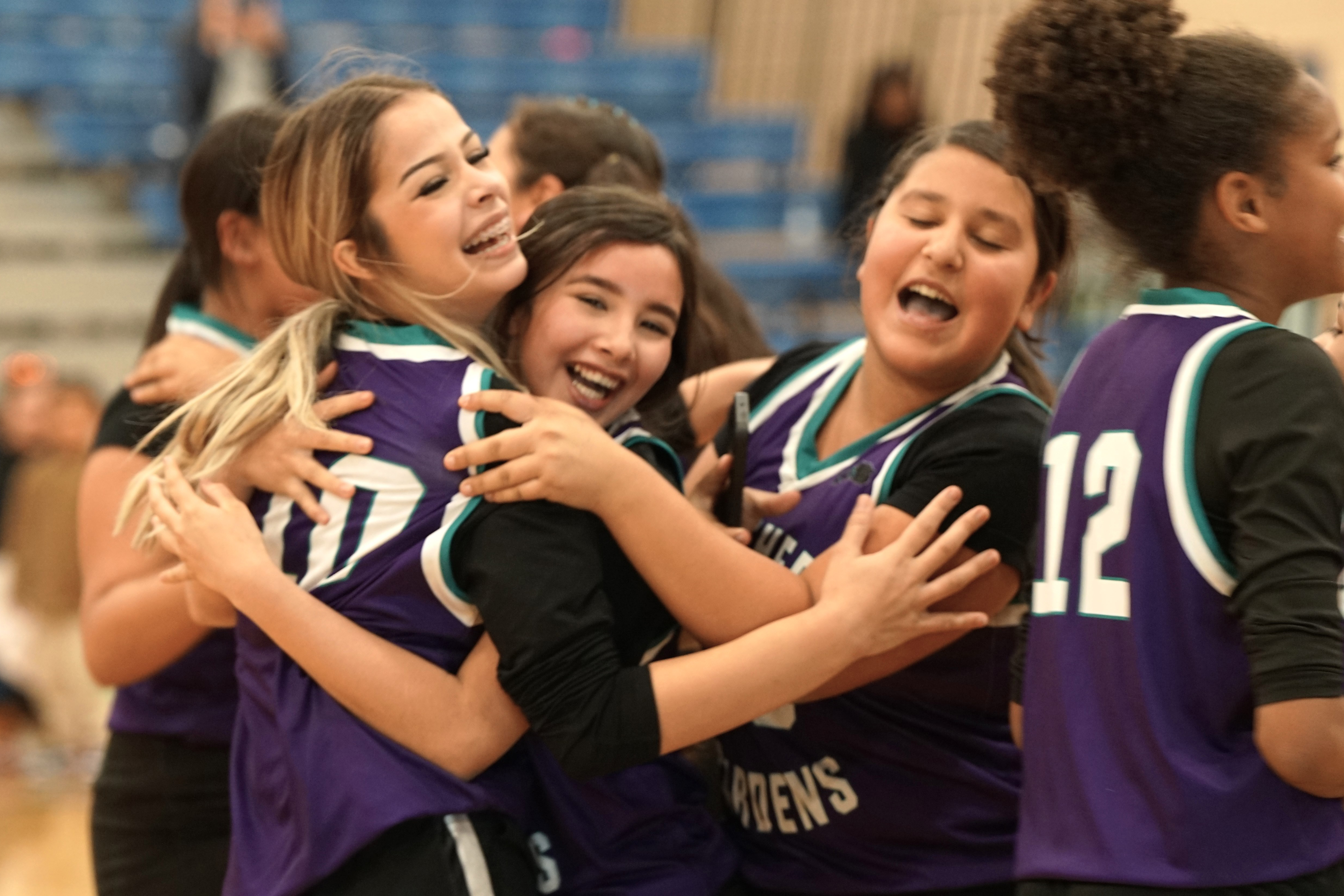 A group of girls hug each other after winning the game