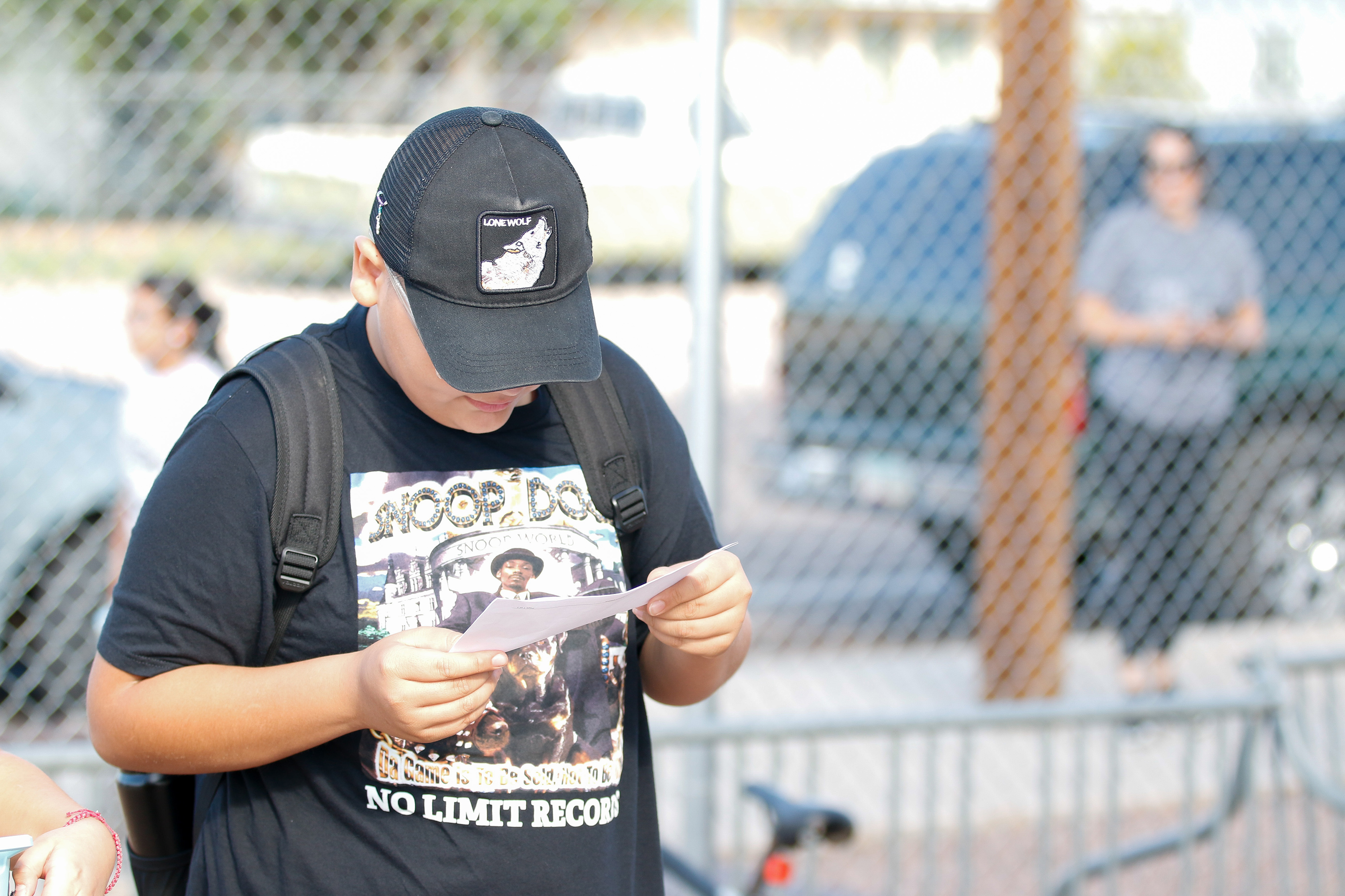 A boy looks over his class schedule outside of school