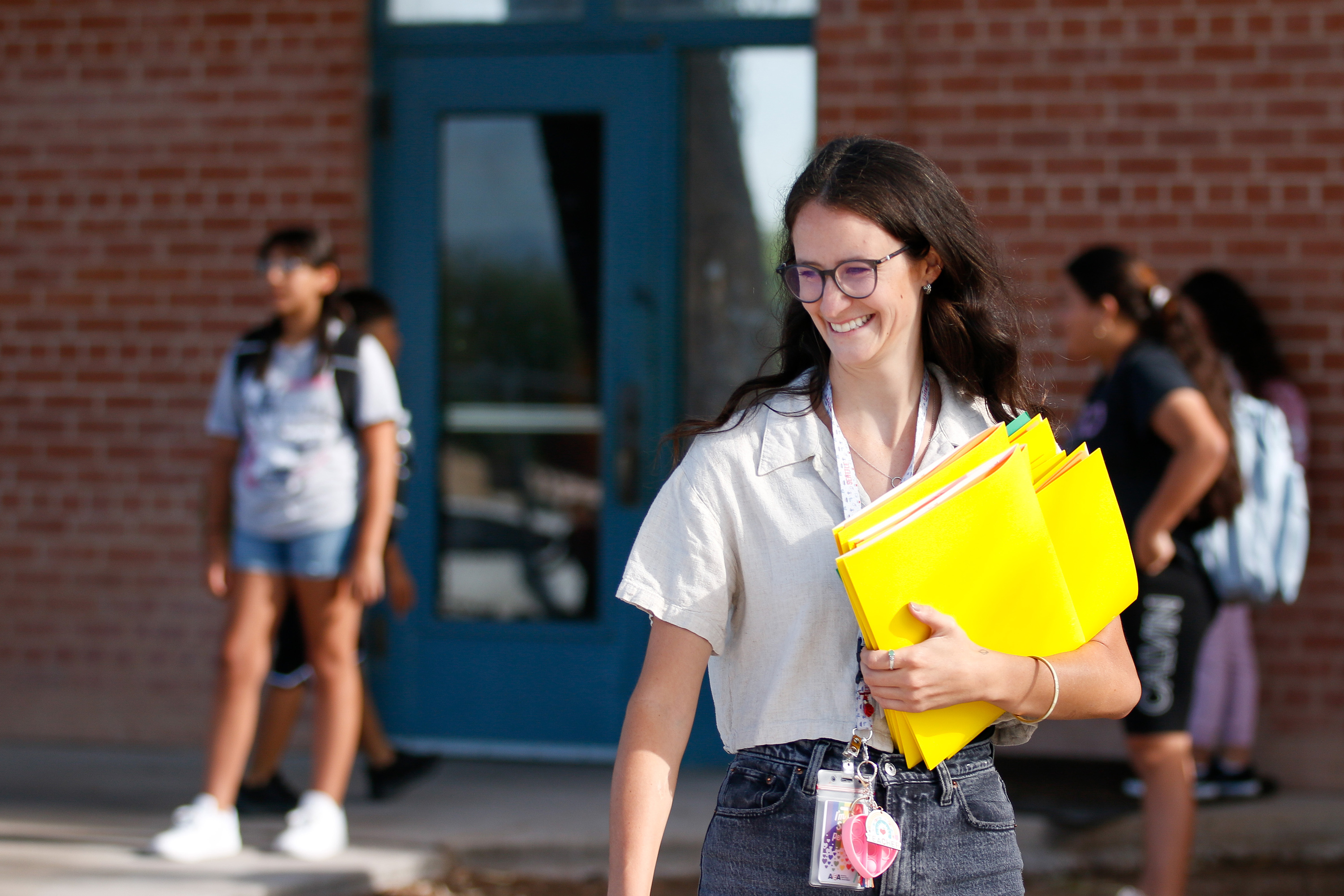 A teacher smiles as she walks outside school on the second day