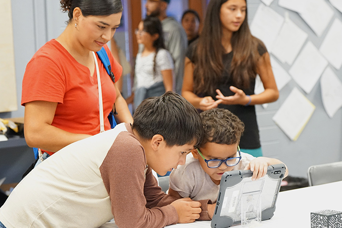 Two boys look at a tablet