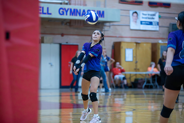 A girl hits the volleyball over the net