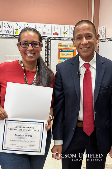 Teacher receives an award from the Superintendent