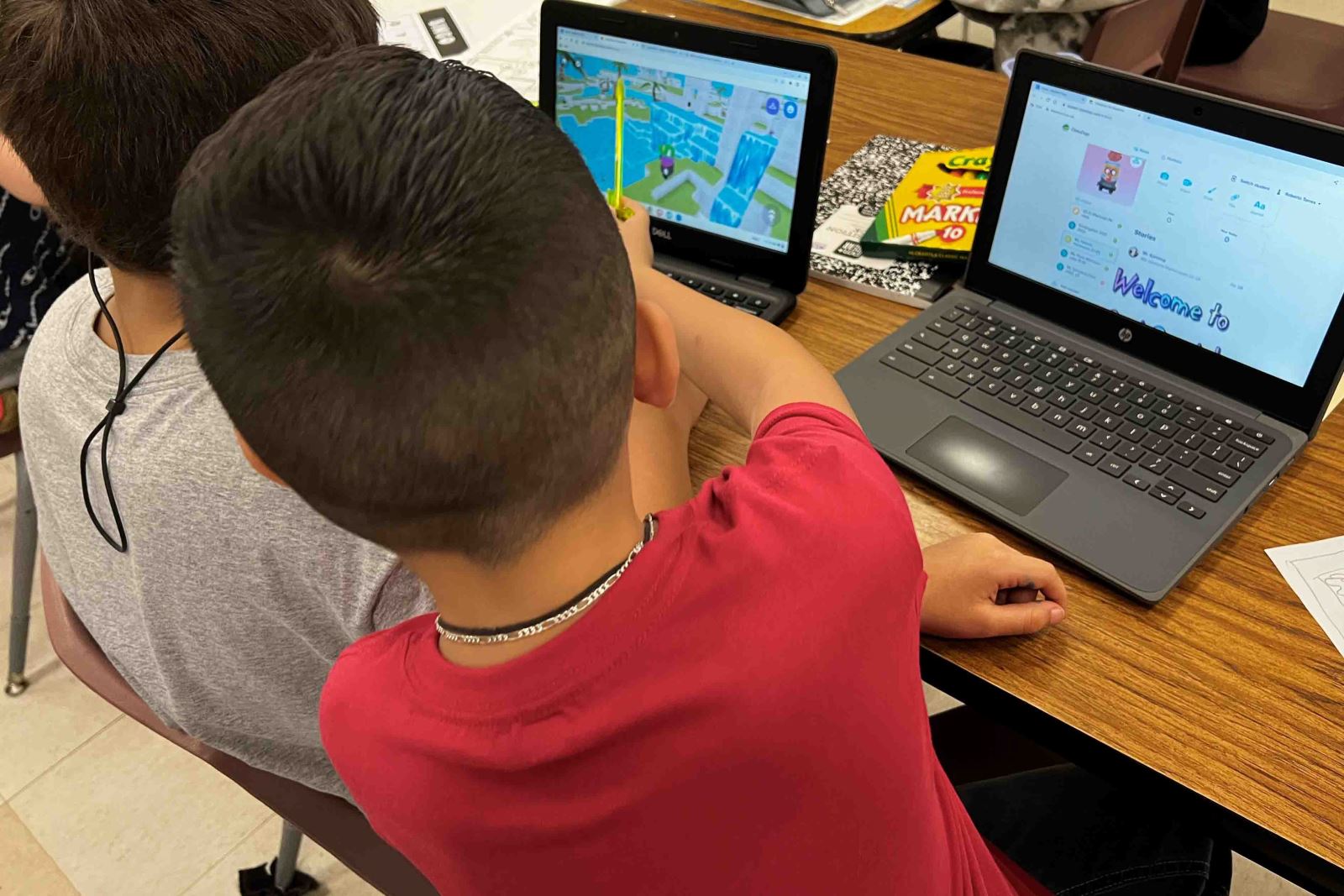 Two Pueblo Gardens students work on their laptops on the first day of school